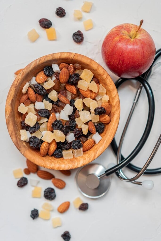 pexels-photo-2837005-2837005 Top view of a healthy mix of nuts and dried fruits with an apple and stethoscope.