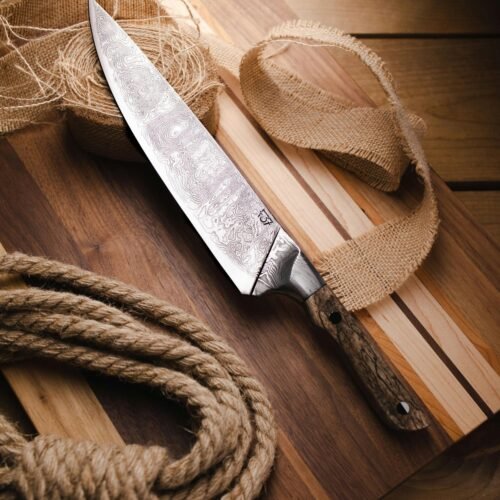 A beautifully crafted chef's knife placed on a wooden board with rustic ropes. Perfect for culinary use.